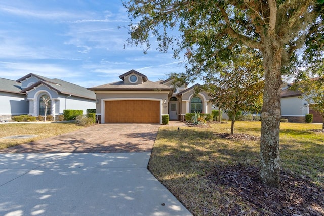 ranch-style home featuring a garage and a front lawn