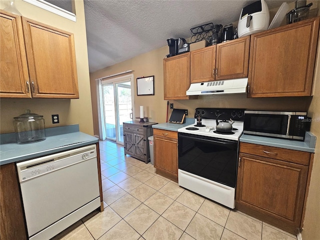 kitchen featuring white dishwasher, light tile patterned floors, a textured ceiling, and range with electric stovetop