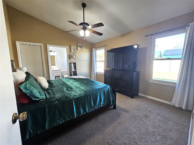 carpeted bedroom featuring connected bathroom, a textured ceiling, vaulted ceiling, and ceiling fan