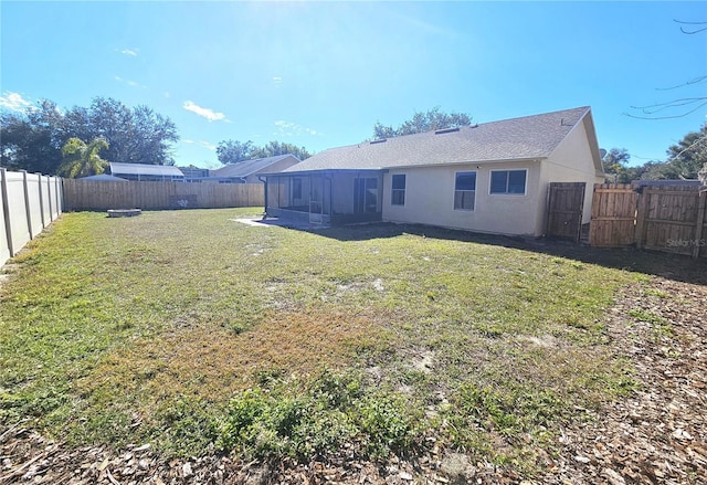 back of property featuring a sunroom and a lawn