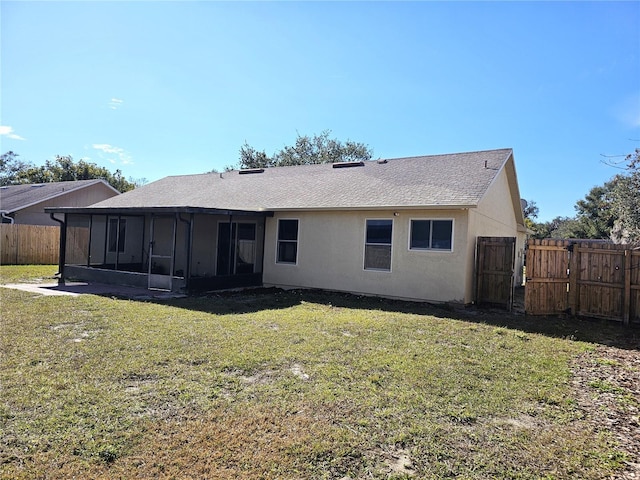 back of property featuring a sunroom and a yard