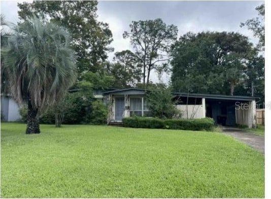 view of front of property with driveway, a front lawn, and an attached carport