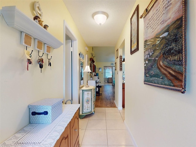 hallway with light tile patterned floors and a textured ceiling