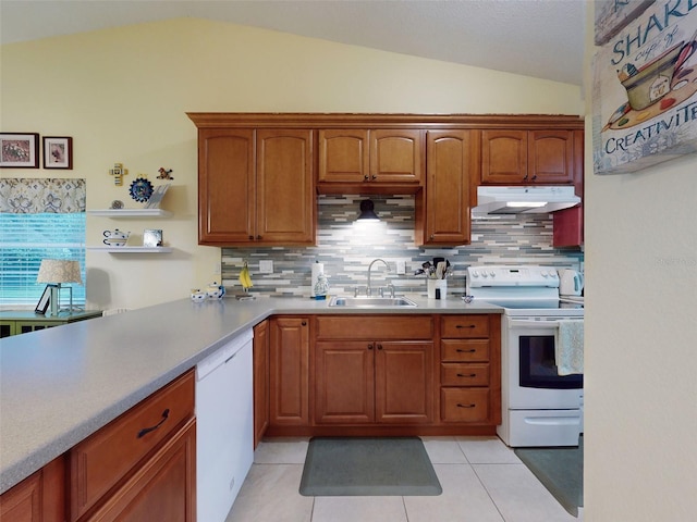 kitchen featuring sink, white appliances, light tile patterned floors, decorative backsplash, and vaulted ceiling