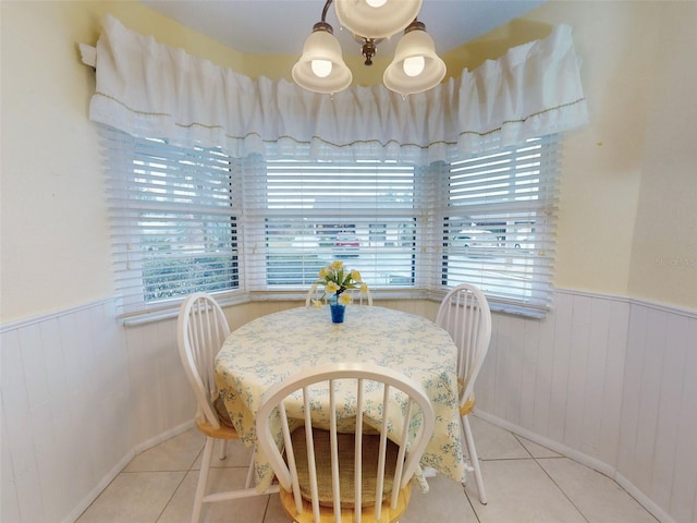 tiled dining space featuring a healthy amount of sunlight and a chandelier