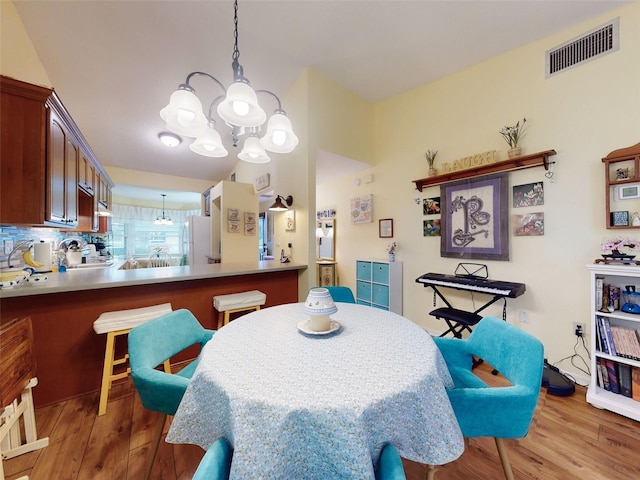 dining space featuring an inviting chandelier and light hardwood / wood-style floors