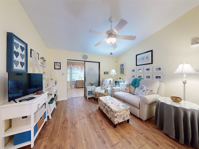 living room featuring hardwood / wood-style flooring, ceiling fan, and vaulted ceiling