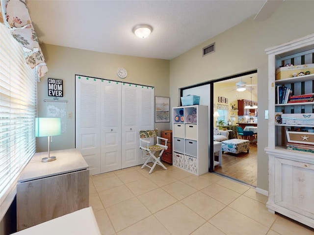 interior space featuring ceiling fan, tile patterned floors, and a textured ceiling