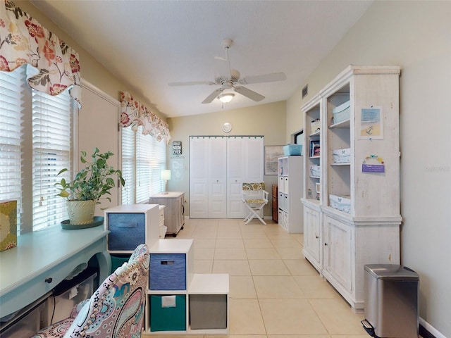 office space featuring ceiling fan, lofted ceiling, and light tile patterned floors