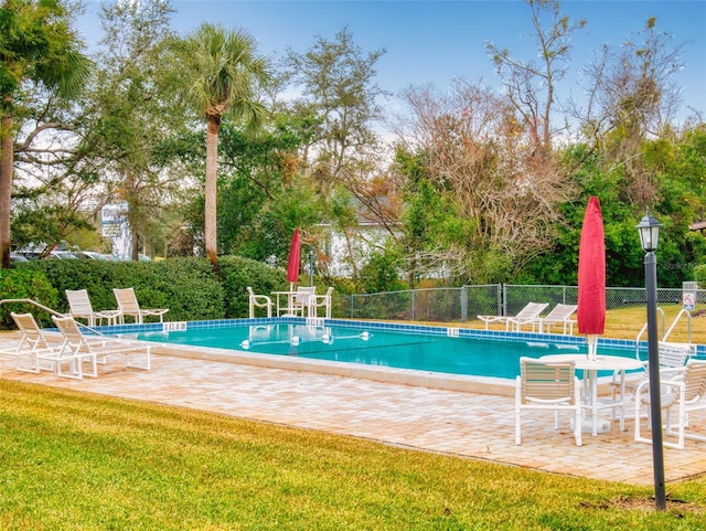 view of swimming pool featuring a yard and a patio