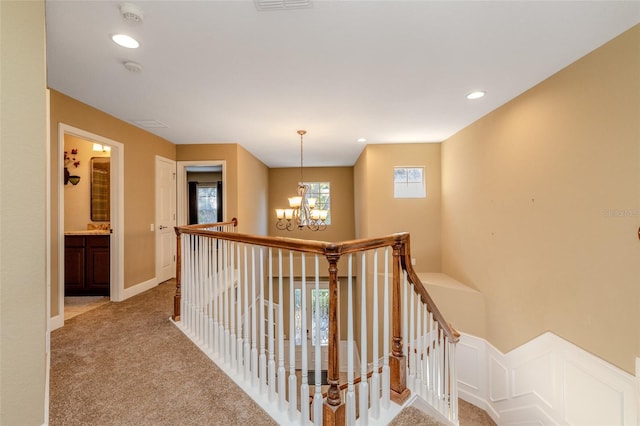 hallway featuring carpet floors, recessed lighting, an inviting chandelier, an upstairs landing, and baseboards