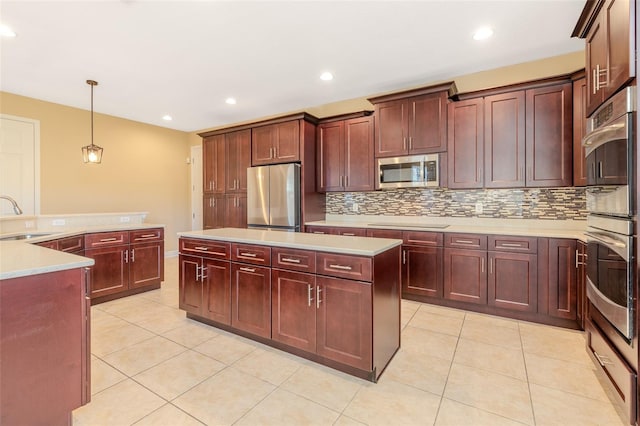 kitchen featuring stainless steel appliances, dark brown cabinets, a sink, and a center island