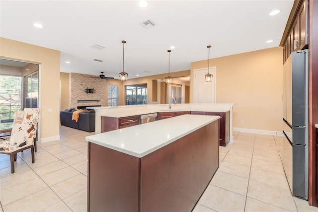 kitchen with visible vents, dishwasher, open floor plan, a large island with sink, and a sink