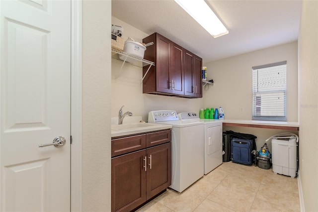 washroom featuring cabinet space, a sink, washer and clothes dryer, and light tile patterned flooring