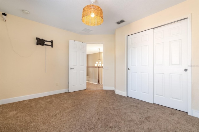 unfurnished bedroom with baseboards, a closet, visible vents, and carpet flooring