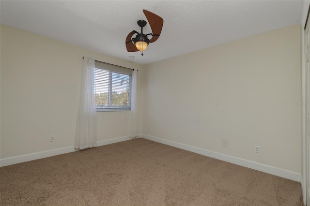 unfurnished room with a ceiling fan, carpet flooring, and baseboards