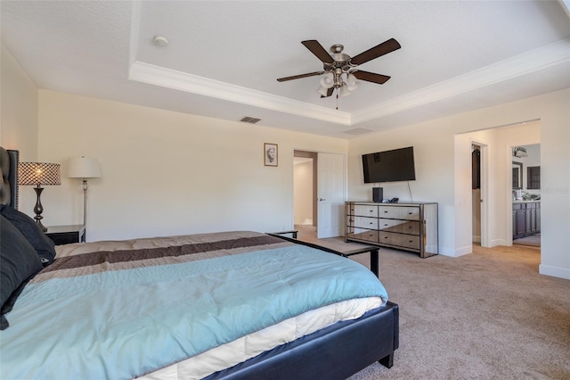 carpeted bedroom featuring visible vents, baseboards, ceiling fan, a tray ceiling, and crown molding