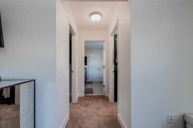 corridor featuring carpet flooring and baseboards