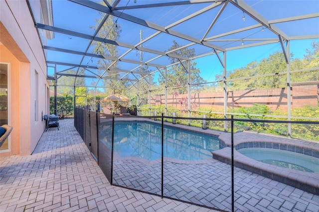 view of swimming pool with a lanai, a patio area, and a pool with connected hot tub