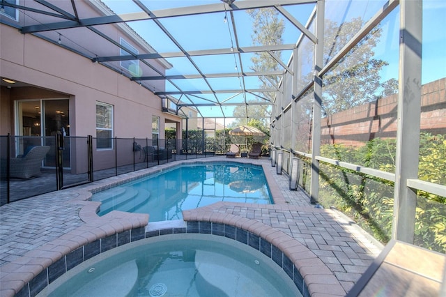 view of swimming pool featuring a lanai, a pool with connected hot tub, fence, and a patio