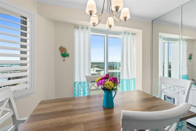 dining space featuring ornamental molding and a notable chandelier