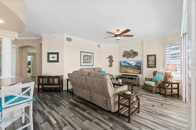 living room with crown molding, ceiling fan, dark hardwood / wood-style flooring, and decorative columns