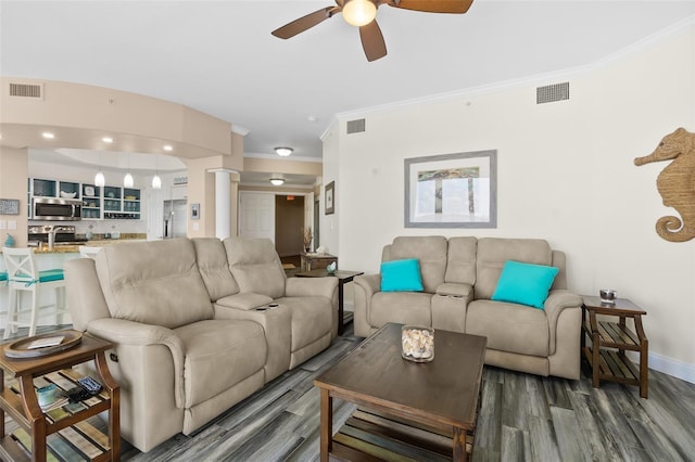 living room featuring sink, ornamental molding, dark hardwood / wood-style floors, ceiling fan, and decorative columns