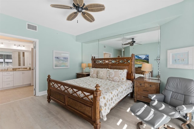 bedroom with sink, light wood-type flooring, ceiling fan, and ensuite bathroom