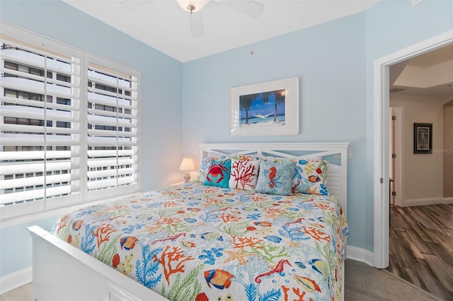 bedroom with multiple windows, hardwood / wood-style floors, and ceiling fan