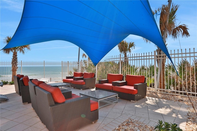 view of patio featuring a view of the beach, an outdoor living space, and a water view