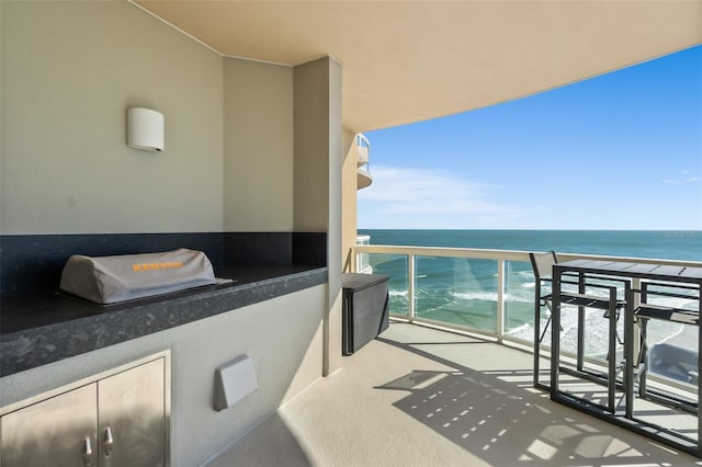 balcony with a water view and exterior kitchen