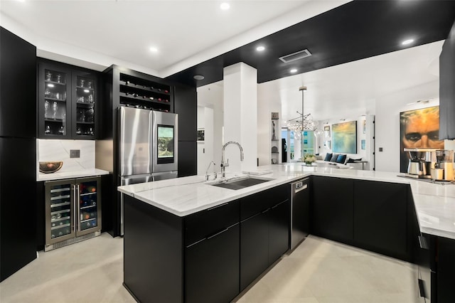 kitchen with sink, stainless steel refrigerator, black dishwasher, pendant lighting, and beverage cooler