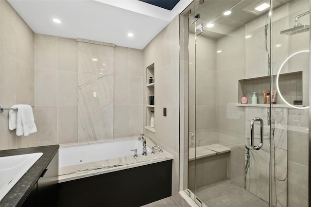 bathroom with vanity, tile walls, and separate shower and tub