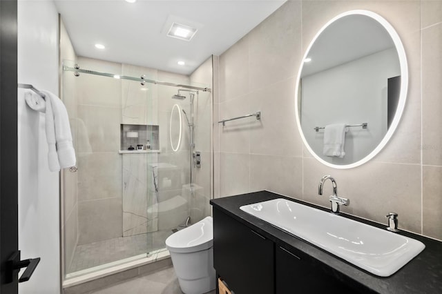 bathroom featuring walk in shower, tile walls, vanity, and toilet