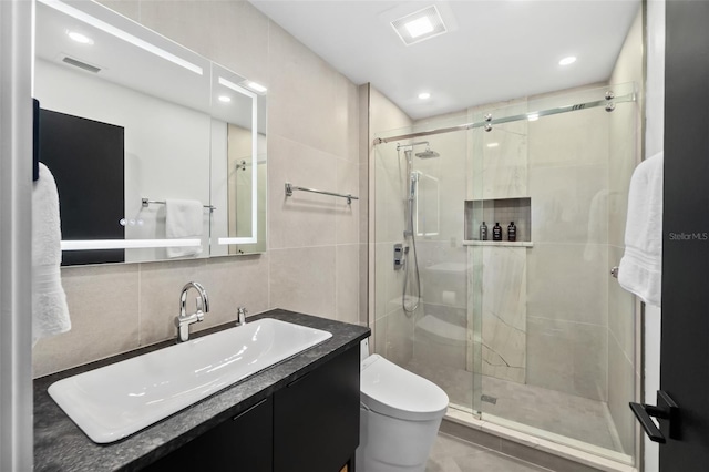 bathroom with tile walls, decorative backsplash, vanity, an enclosed shower, and toilet