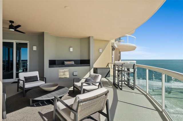 balcony featuring a water view and ceiling fan