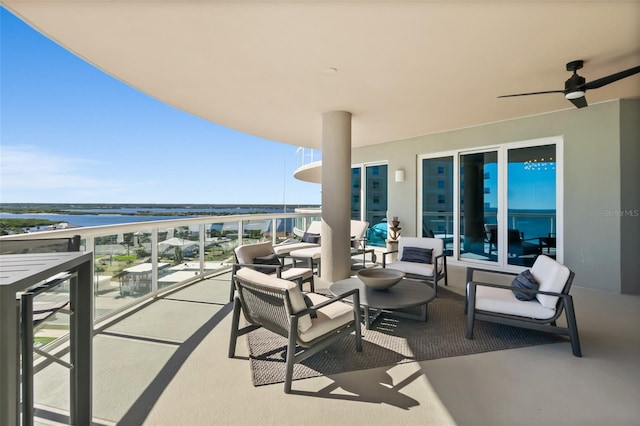 balcony featuring a water view and ceiling fan