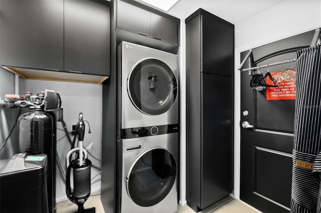 laundry area featuring cabinets and stacked washer / drying machine