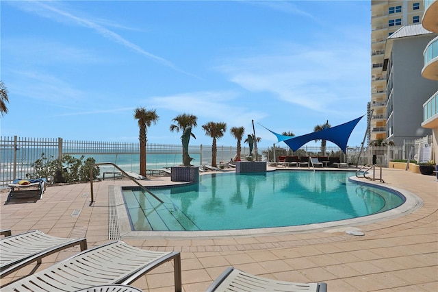 view of pool with a patio area and a water view