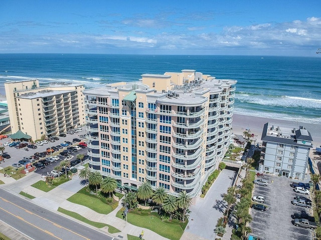 drone / aerial view featuring a beach view and a water view