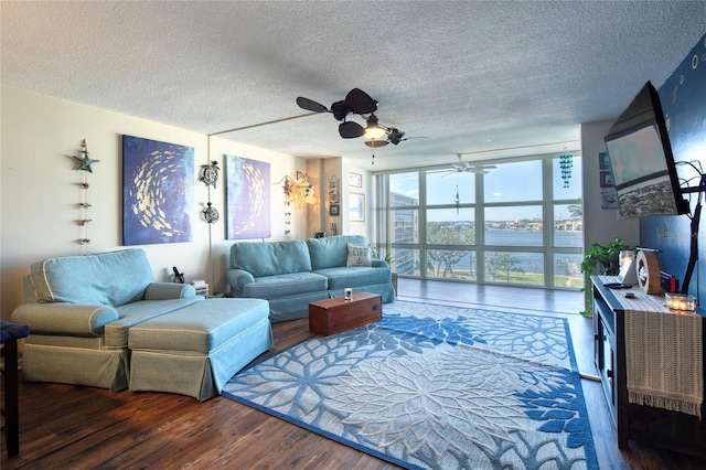 living room featuring dark wood-type flooring, ceiling fan, floor to ceiling windows, and a textured ceiling