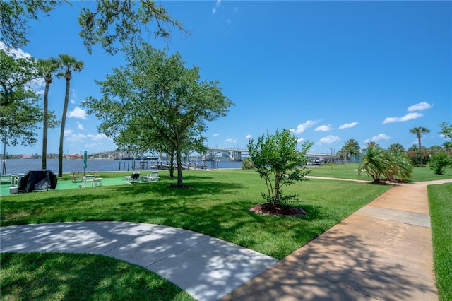 view of property's community with a lawn and a water view