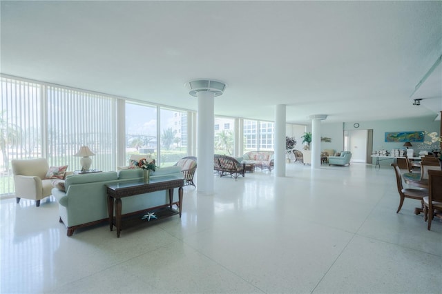 living room with a wall of windows and decorative columns