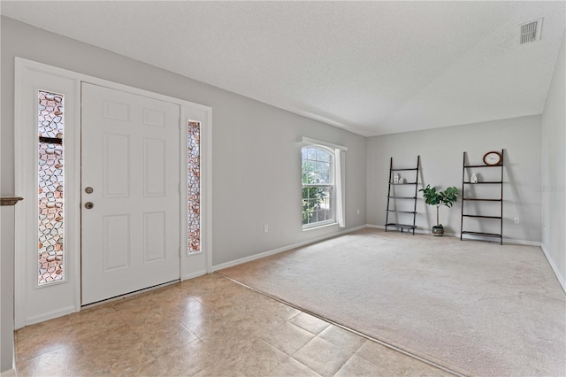 carpeted entrance foyer with a textured ceiling