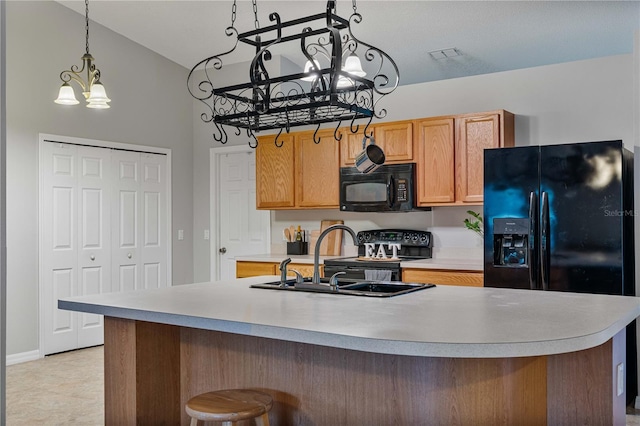 kitchen with pendant lighting, an island with sink, lofted ceiling, sink, and black appliances