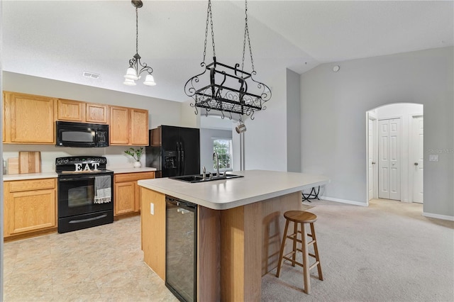 kitchen with vaulted ceiling, sink, wine cooler, a center island, and black appliances