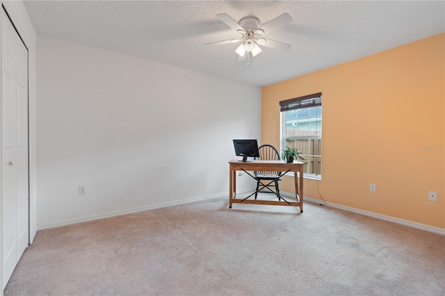 office space with ceiling fan, light colored carpet, and a textured ceiling