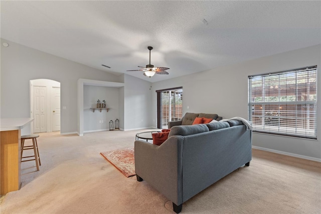 carpeted living room featuring vaulted ceiling, a healthy amount of sunlight, a textured ceiling, and ceiling fan