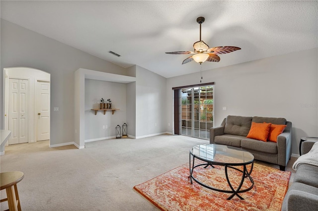 carpeted living room featuring a textured ceiling, vaulted ceiling, and ceiling fan