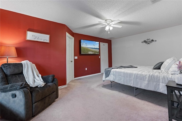 bedroom featuring ceiling fan, light carpet, and a textured ceiling